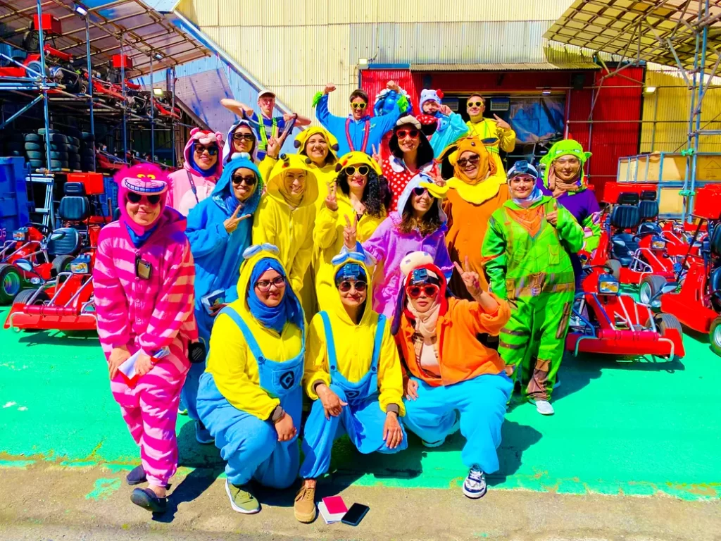 IMG_0643 - StreetKart Group of people in bright Minion costumes posing for a photo at a go-kart track.